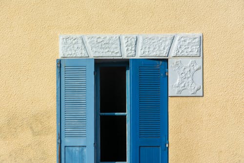Window with Shutters on Yellow Building Wall