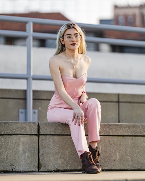 Young Woman in a Pink Outfit Sitting Outside 