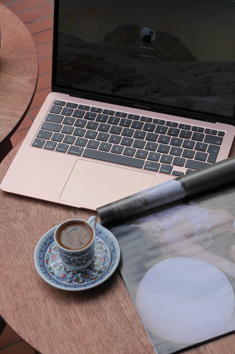 A Coffee And A Laptop On A Table