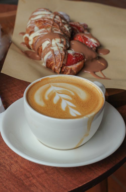 Free Close-up of a Cappuccino and a Croissant with Chocolate and Strawberries  Stock Photo