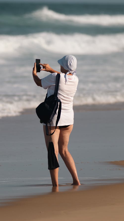 A Woman with a Smartphone on a Beach