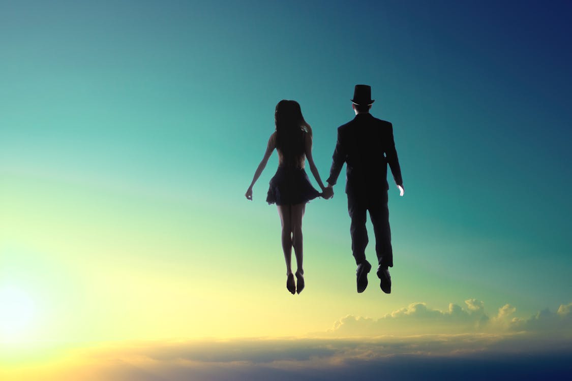 Free Man And Woman Floating On Sky Stock Photo