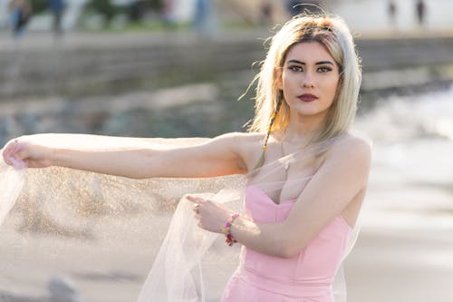 Blonde Woman Wearing Pink Dress in a Park