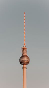 Striking image of Berlin's iconic TV Tower glowing warmly at sunset.