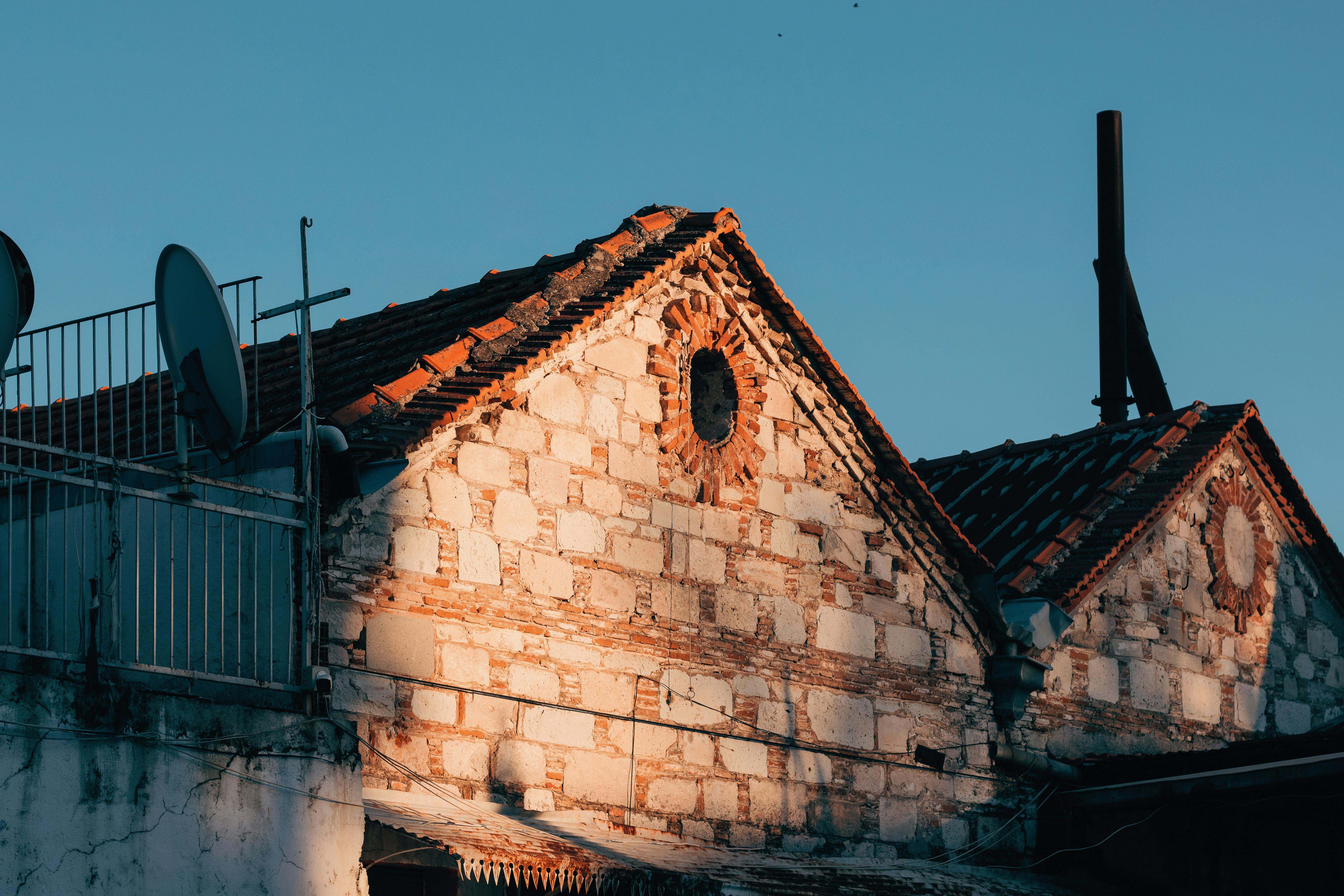 the sun is setting over an old building