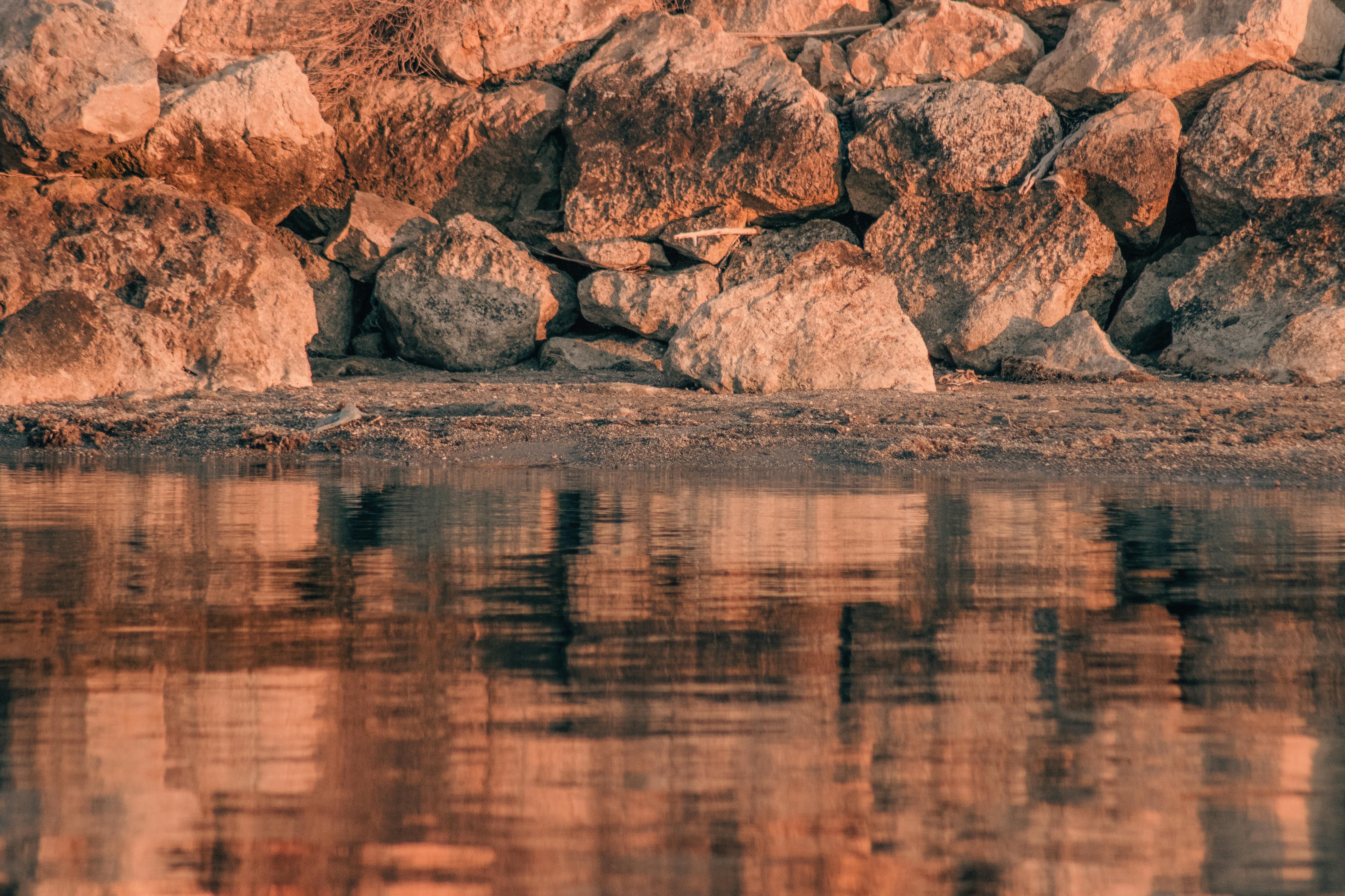 a rock wall with water reflecting it