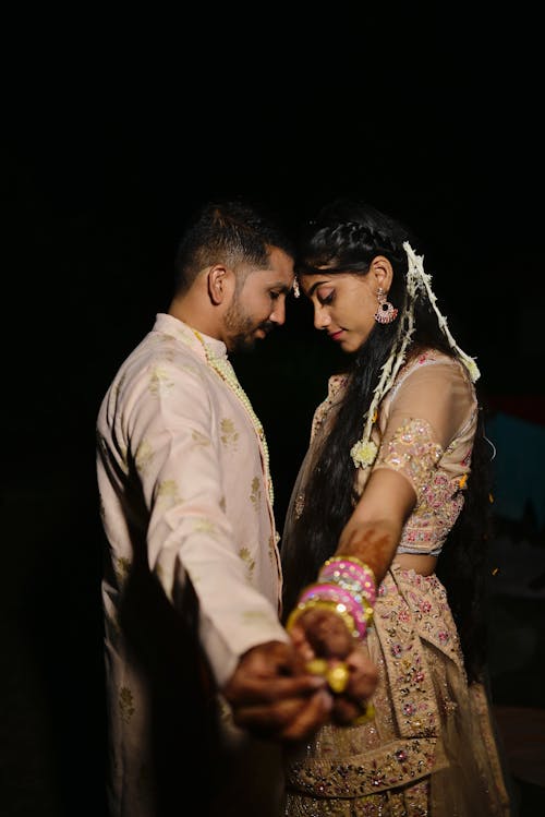 Newlyweds Holding Hands in Traditional Clothing 