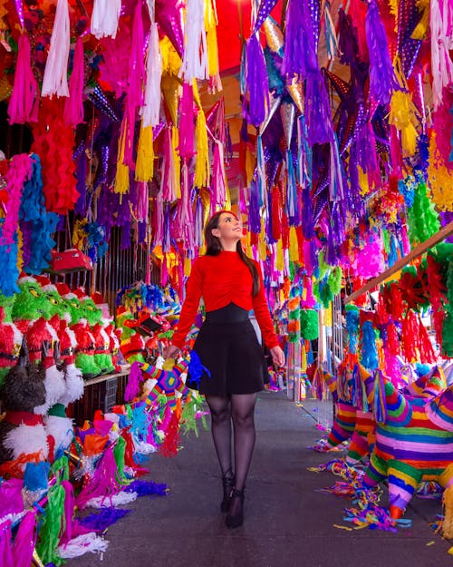 Free A woman standing in a market with colorful decorations Stock Photo