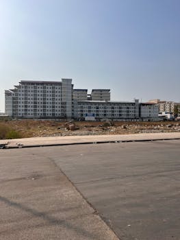 Large apartment complex in urban area under clear blue sky.