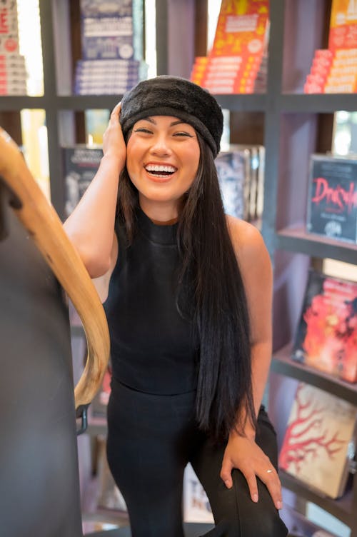 Young Woman in a Black Outfit Standing in a Library 