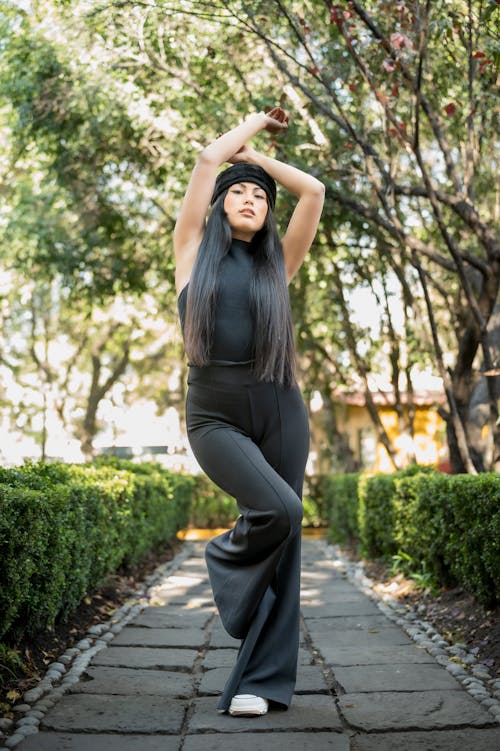 Young Woman in a Fashionable Black Outfit Posing in a Park 