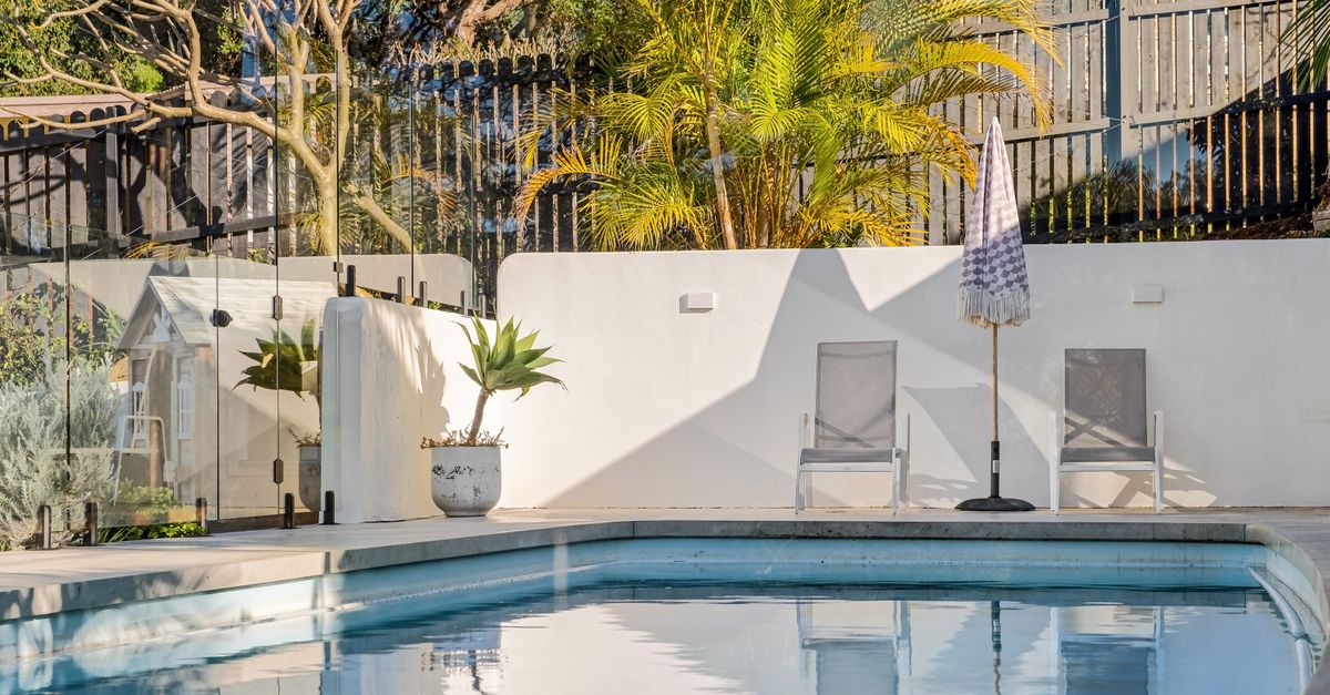 Elegant backyard pool with sun loungers, ideal for a relaxing summer.