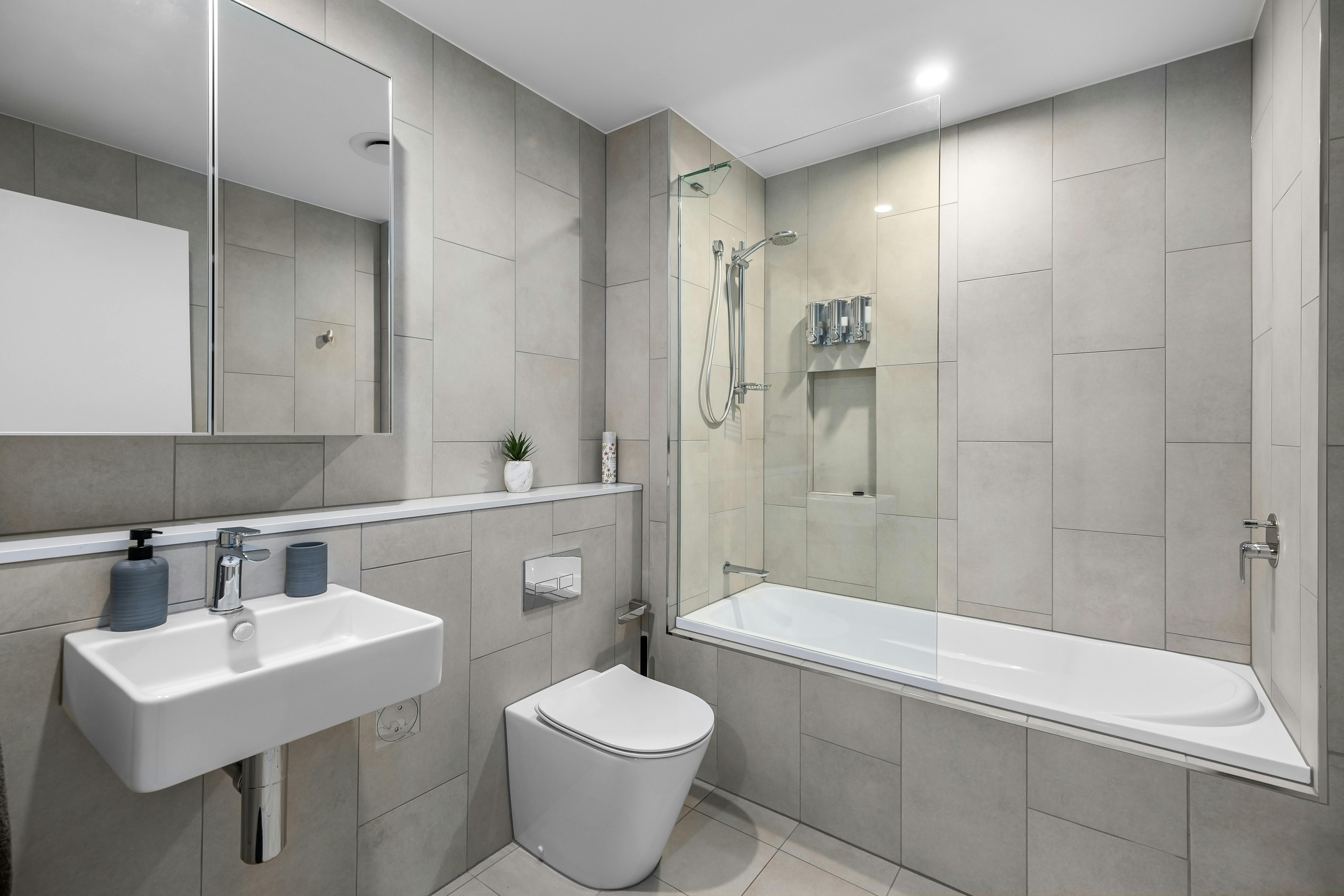 Modernes Badezimmer mit hellen Wandpaneelen über alten Fliesen und sauber abgedichteten Kanten