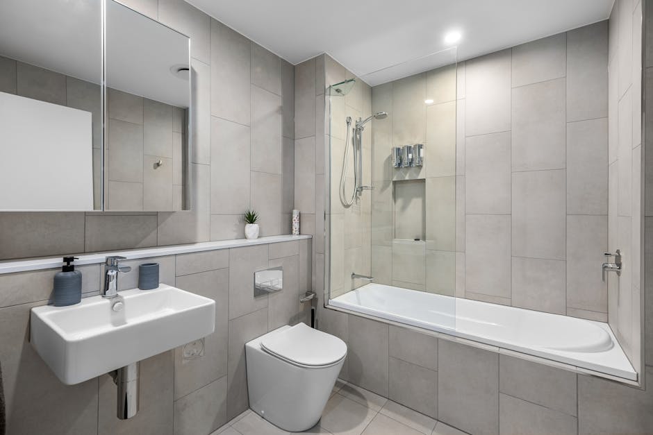 Modernes Badezimmer mit hellen Wandpaneelen über alten Fliesen und sauber abgedichteten Kanten