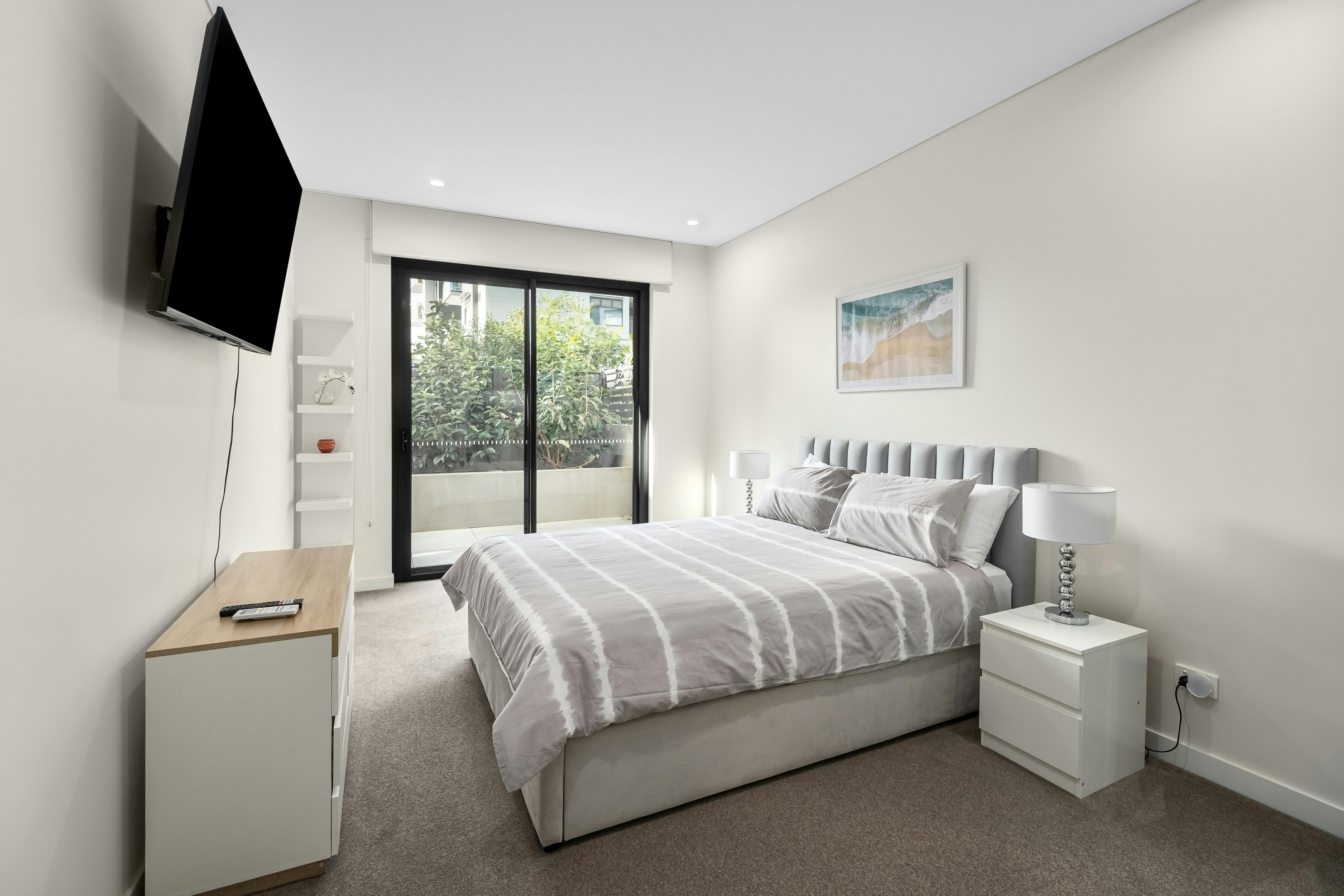 A sleek bedroom interior featuring modern minimalist design and abundant natural light.