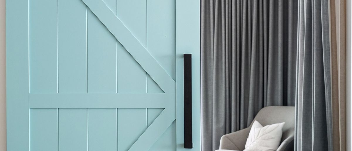 Sliding barn door mounted on a black track in a modern room