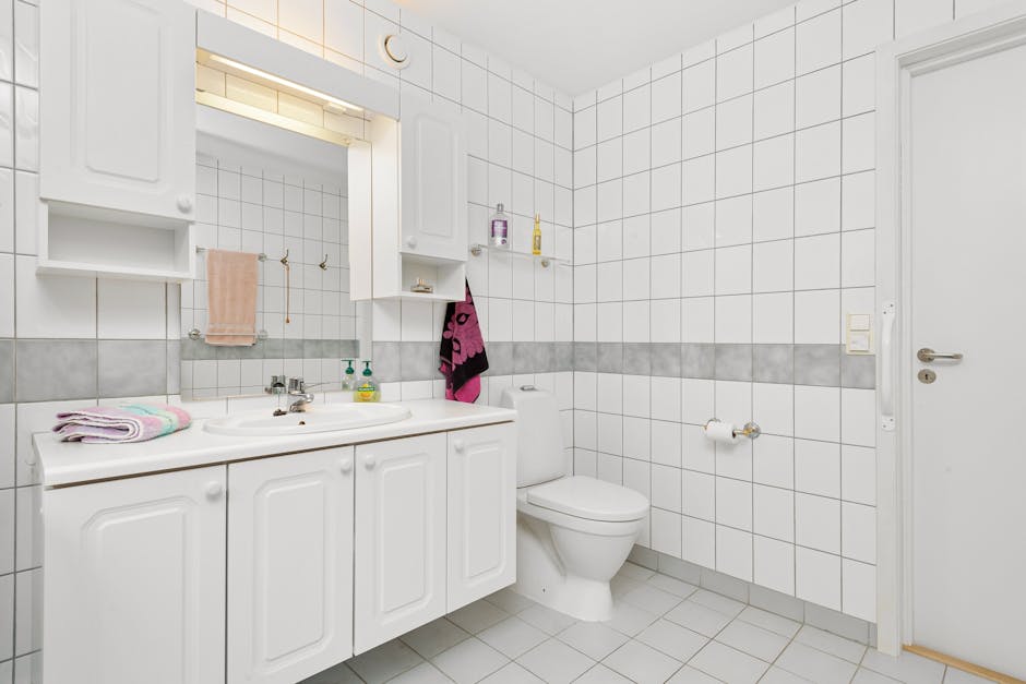 Kleines modernes Bad mit Spiegelschrank über dem Waschtisch, helle Fliesen und weiße Fronten