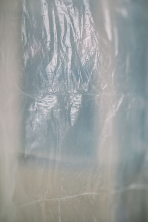 Free Abstract vertical shot highlighting texture of blurred transparent foil. Ideal for backgrounds and creative design. Stock Photo