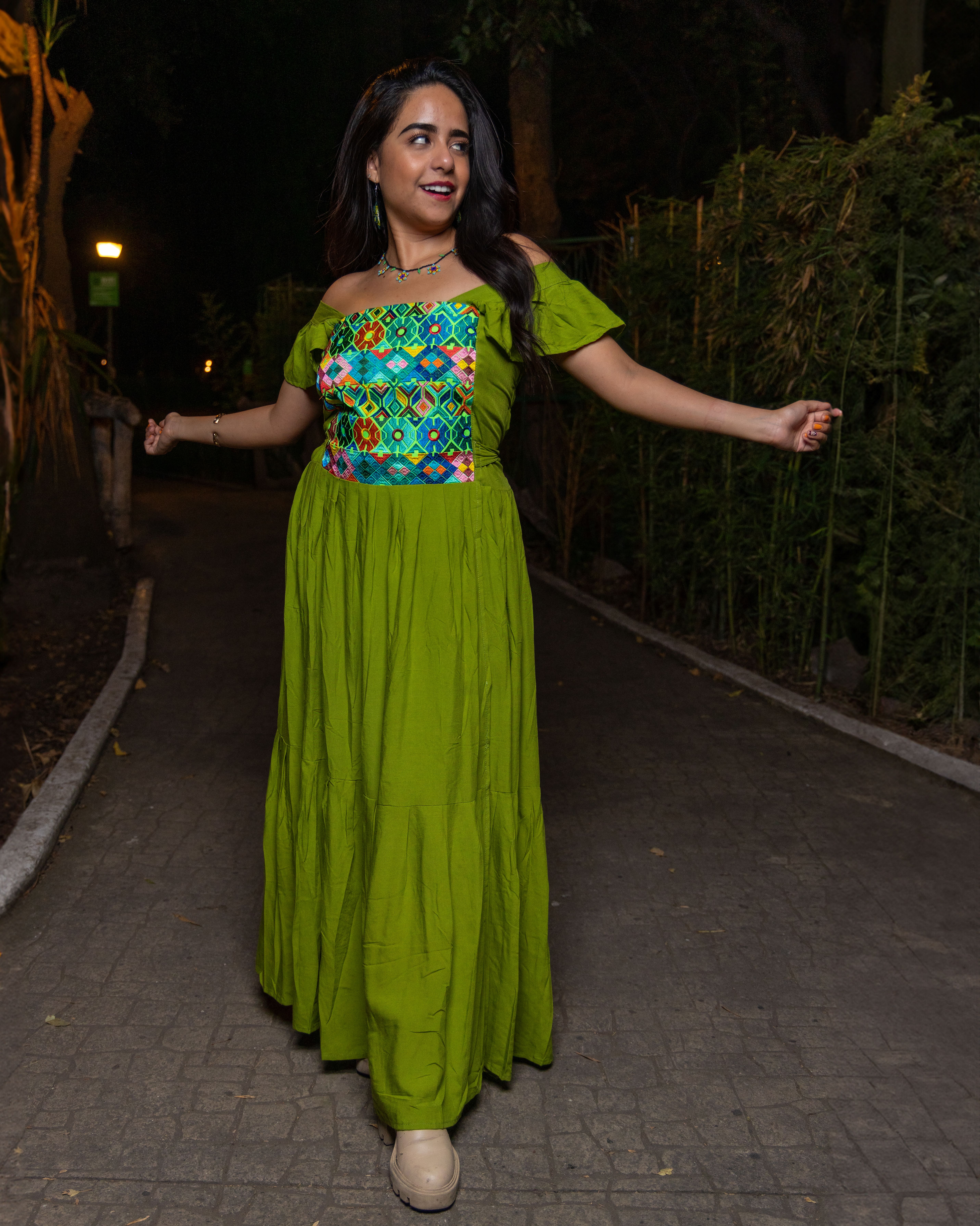 A woman in a green dress is posing for the camera · Free Stock Photo