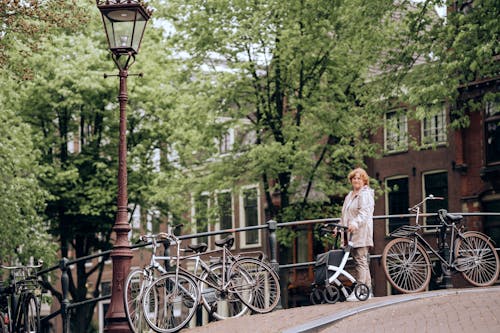 Passerby with a Walker on a Bridge with Bicycles Tied to the Railing