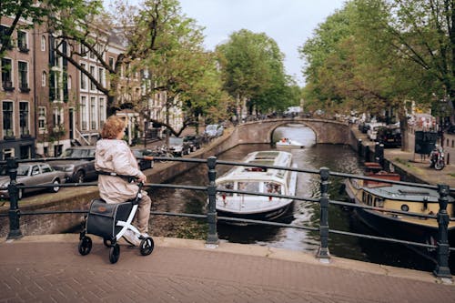 Woman Sitting on Bridge over Canal in Amsterdam