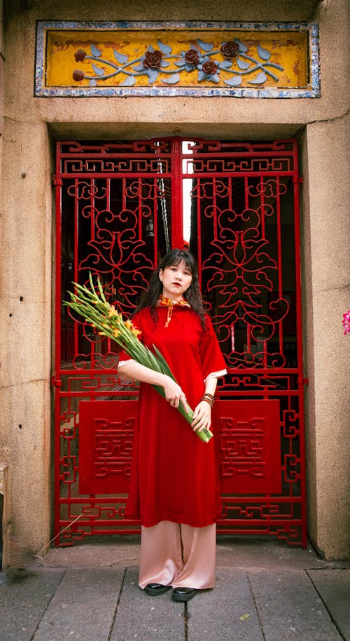Young Woman in an Ao Dai Holding a Bunch of Flowers 