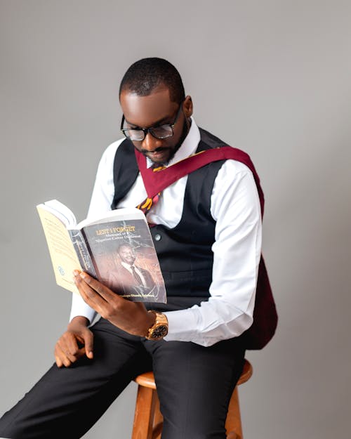 Elegant Man Sitting on a Chair and Reading a Book