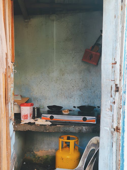 A view of the food stall kitchen with weathered walls and basic cooking utensils.