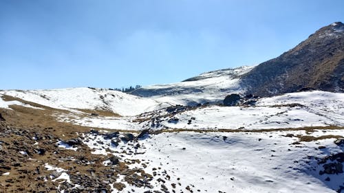 View of Hills Covered in Snow under Blue Sky 