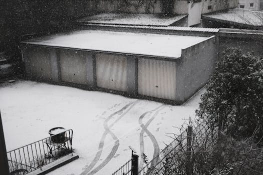 Aerial view of snowy garages in a quiet urban area during wintertime.