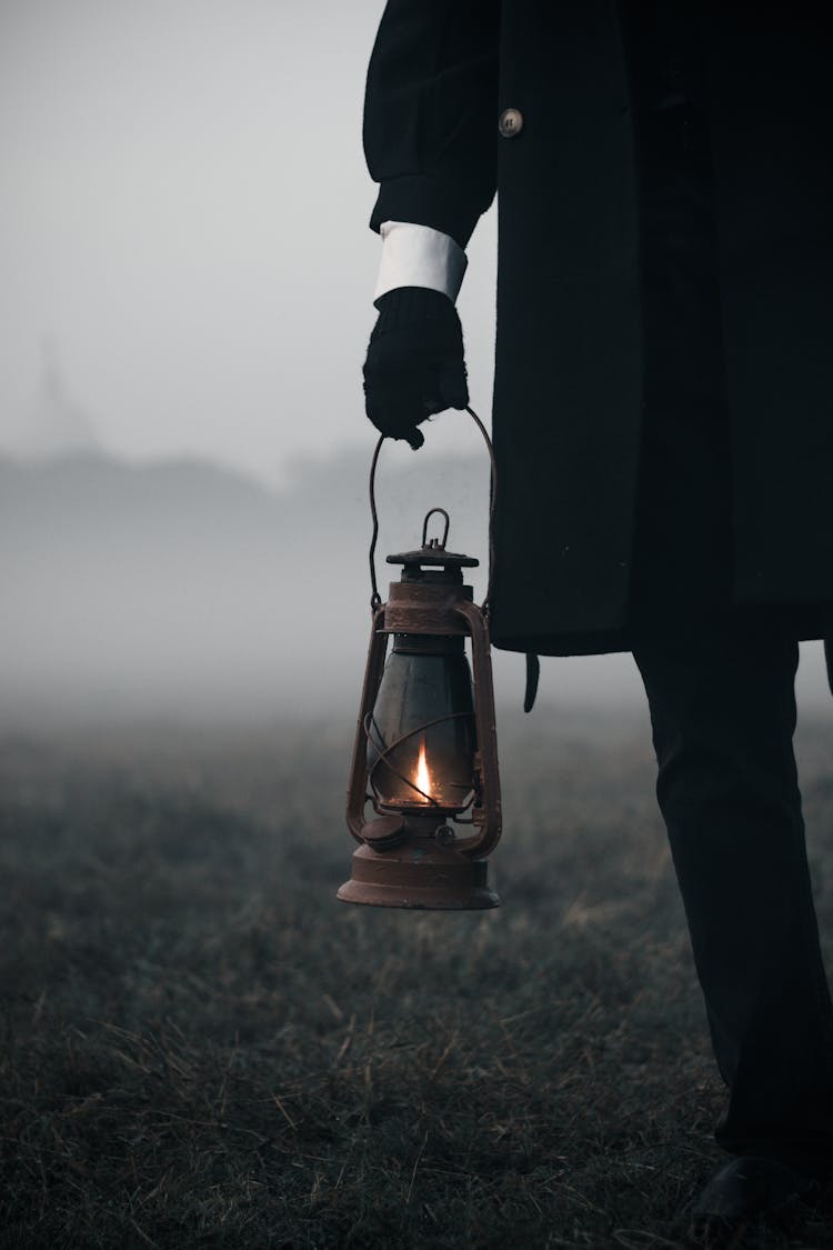 Person In Black Holding Lantern