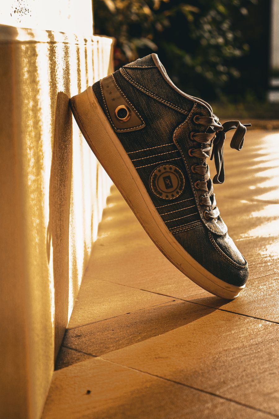 Sneaker leaning against a sunlit wall