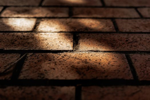Detailed close-up of textured brick pavement with shadow play highlighting urban patterns.