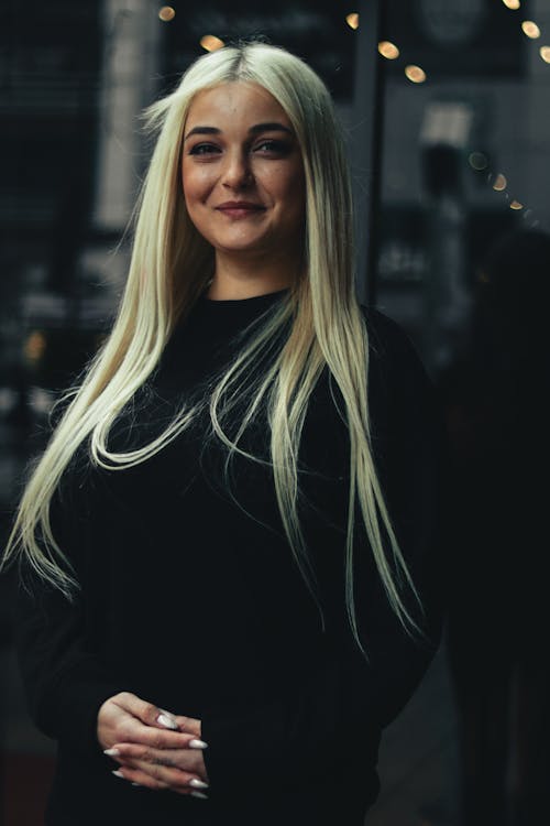 A blonde woman with long hair posing for a photo