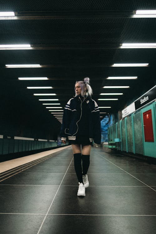 A woman walking down a subway tunnel