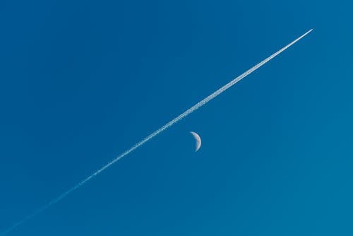 Contrail and Crescent on Clear Sky