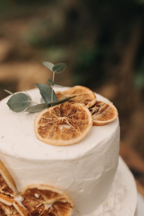Free Elegant rustic wedding cake decorated with dried orange slices and leaves, perfect for unique celebrations. Stock Photo