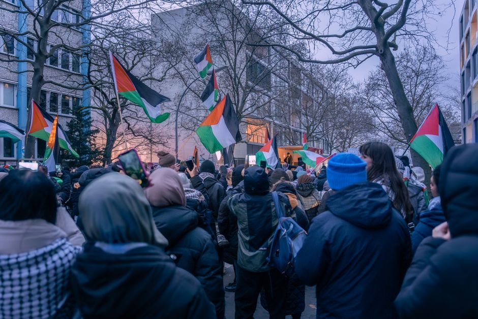 A peaceful protest in Berlin featuring Palestinian flags and diverse participants.