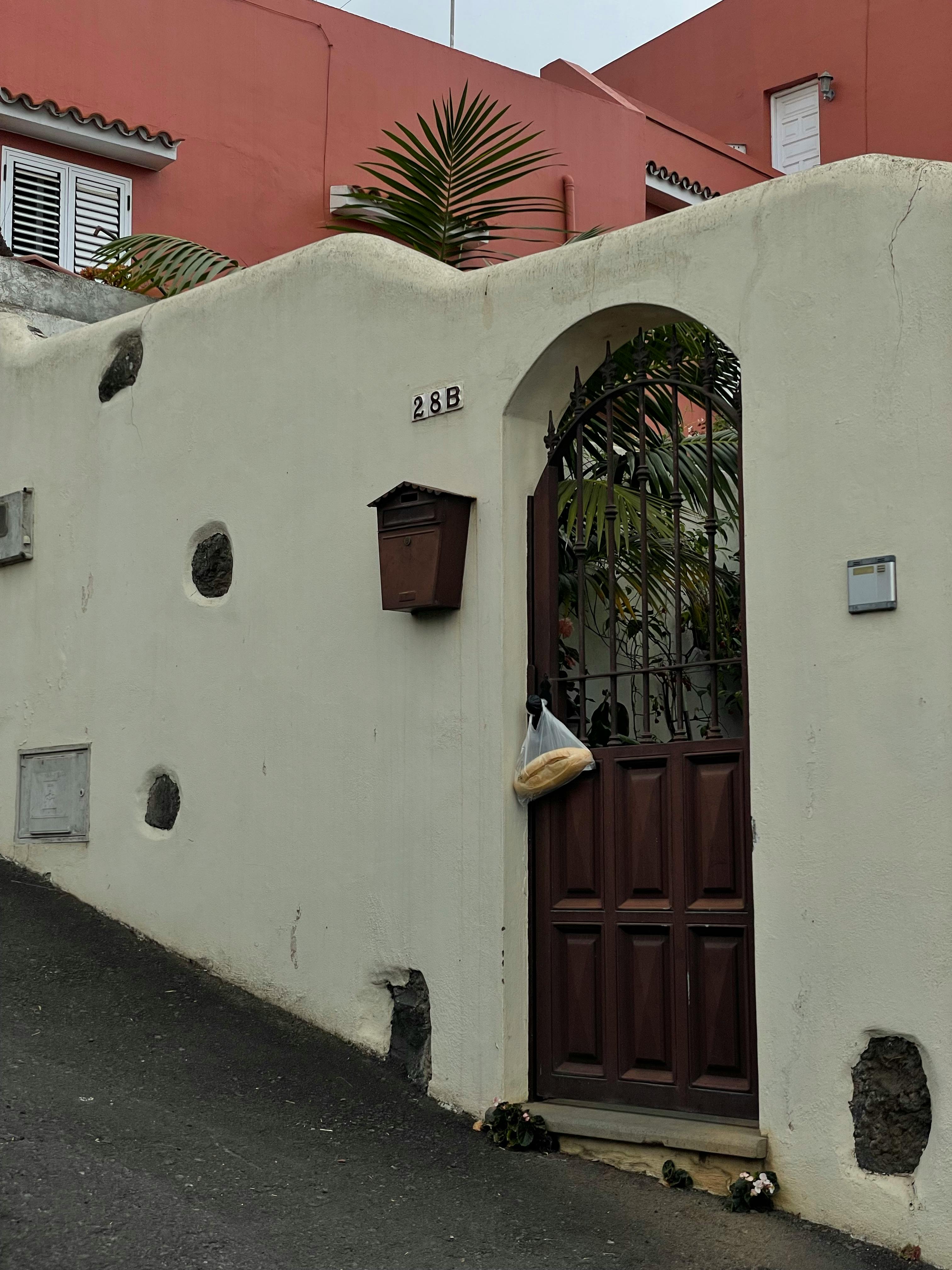Vintage-style gate with bread bag on an urban residential street corner adds character.