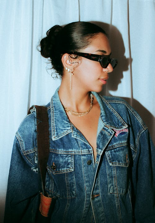 A woman in a denim jacket and sunglasses