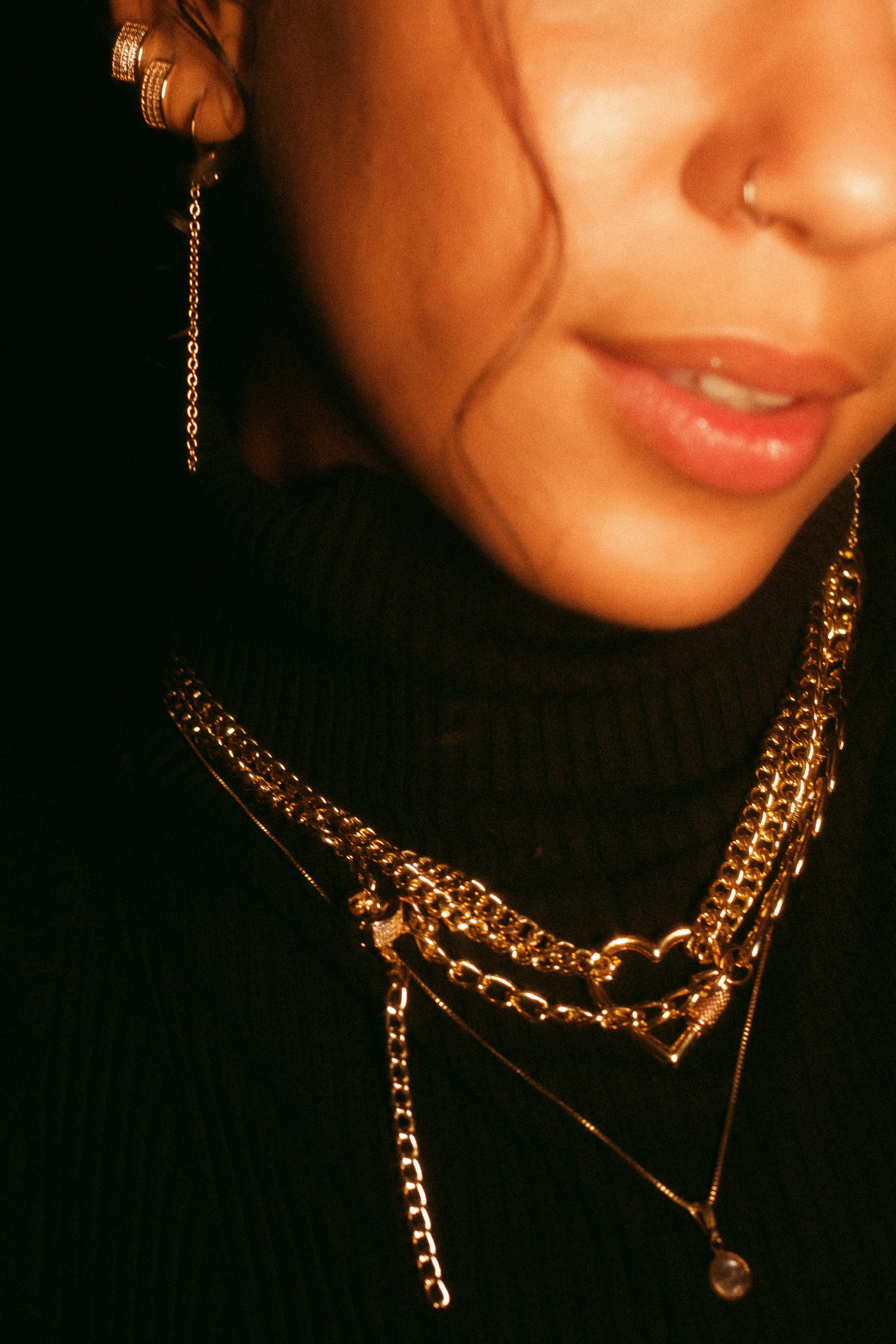 Elegant gold jewelry worn by a woman in a turtleneck, showcasing fashion style.