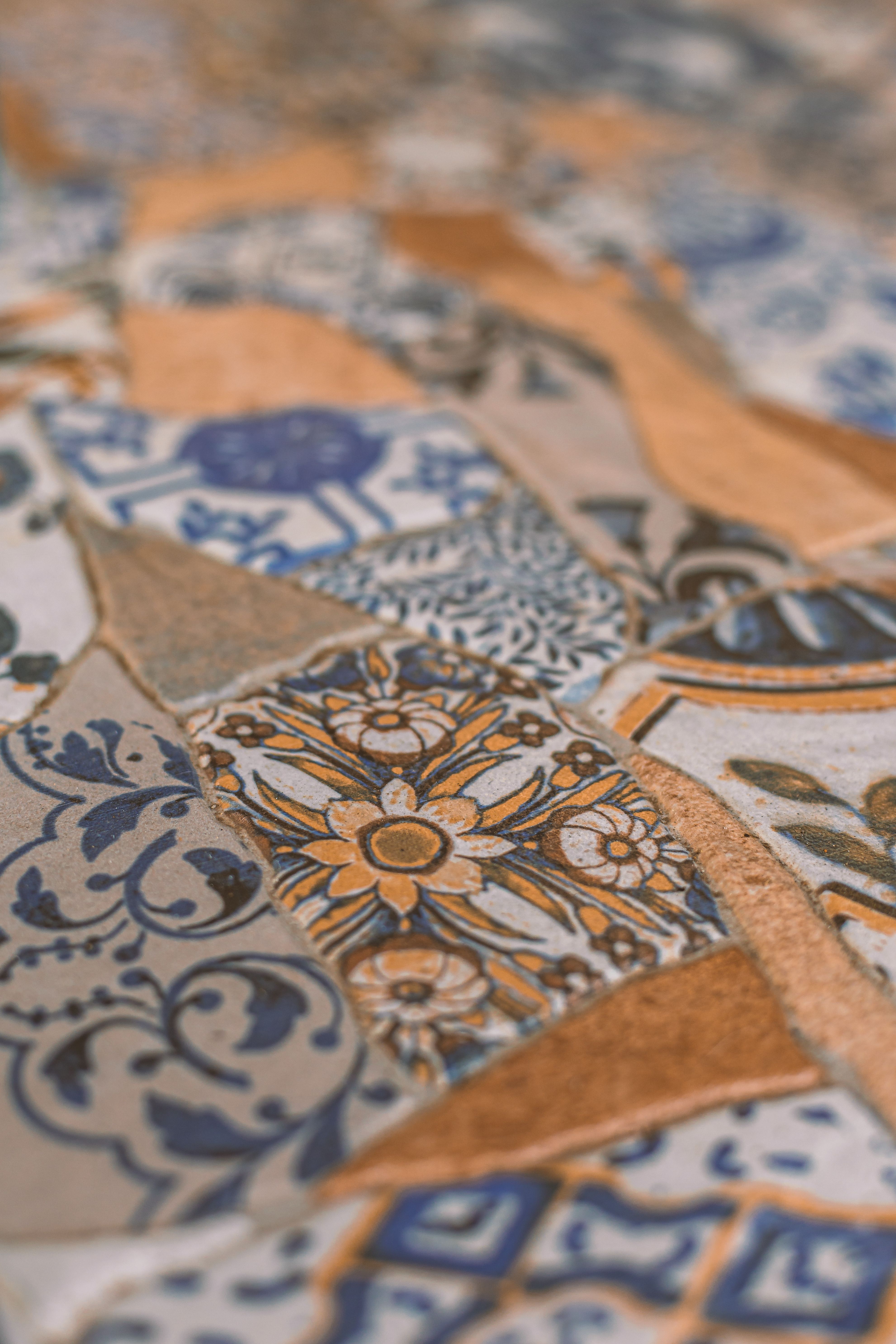 Fotomural Mosaico intrincado con azulejos de diseños florales y geométricos en tonos azules y terracota.