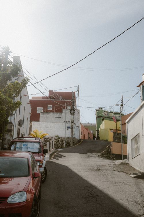 Free Quiet urban street with colorful buildings and cars in daylight, offering a serene view. Stock Photo
