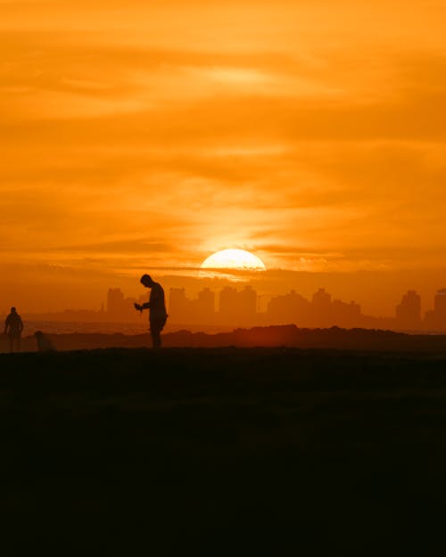 Man at Sunset and City under Yellow Sky behind