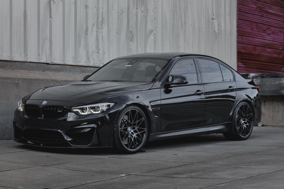 M3 Front View The bmw m3 is parked in front of a garage · Free Stock Photo