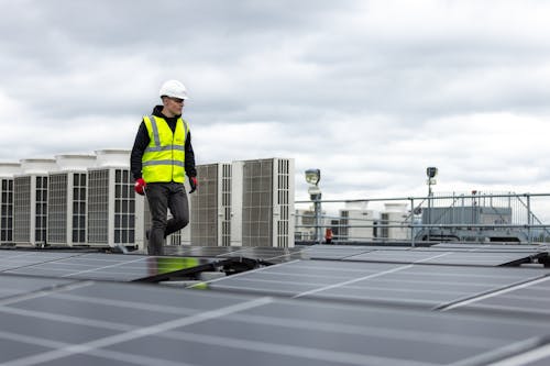 Man Walking on Roof with Solar Panels