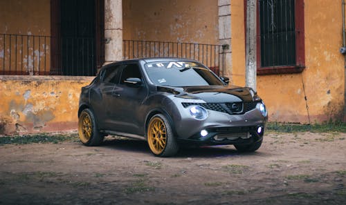 Parked Gray Nissan Juke with its Lights On