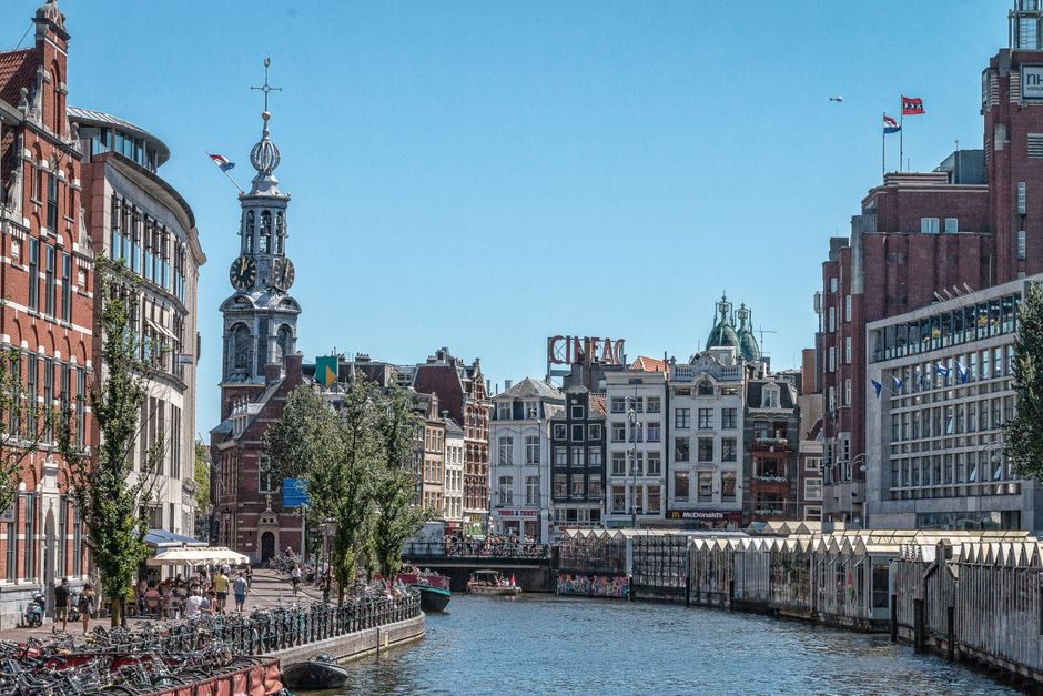Discover the charming canals and historic architecture of Amsterdam on a sunny day.