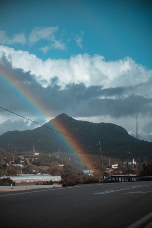 Free Capture of a vivid rainbow over a scenic mountain landscape, creating a breathtaking view. Stock Photo