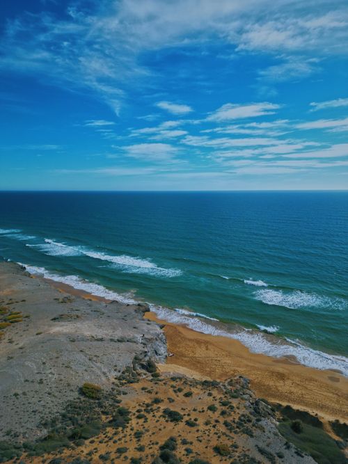 Free A beautiful aerial view of the beach and ocean waves in Cobaticas, Spain, with clear skies and vibrant colors. Stock Photo